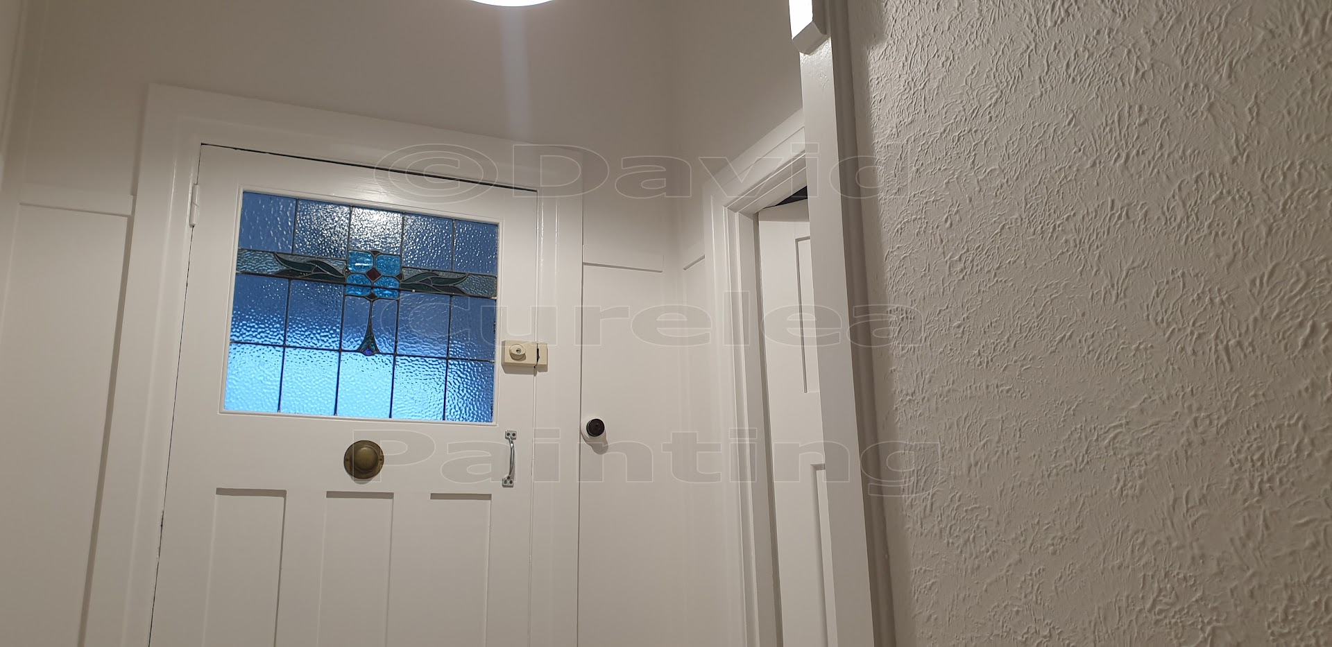 A painted front door with a small leadlight panel