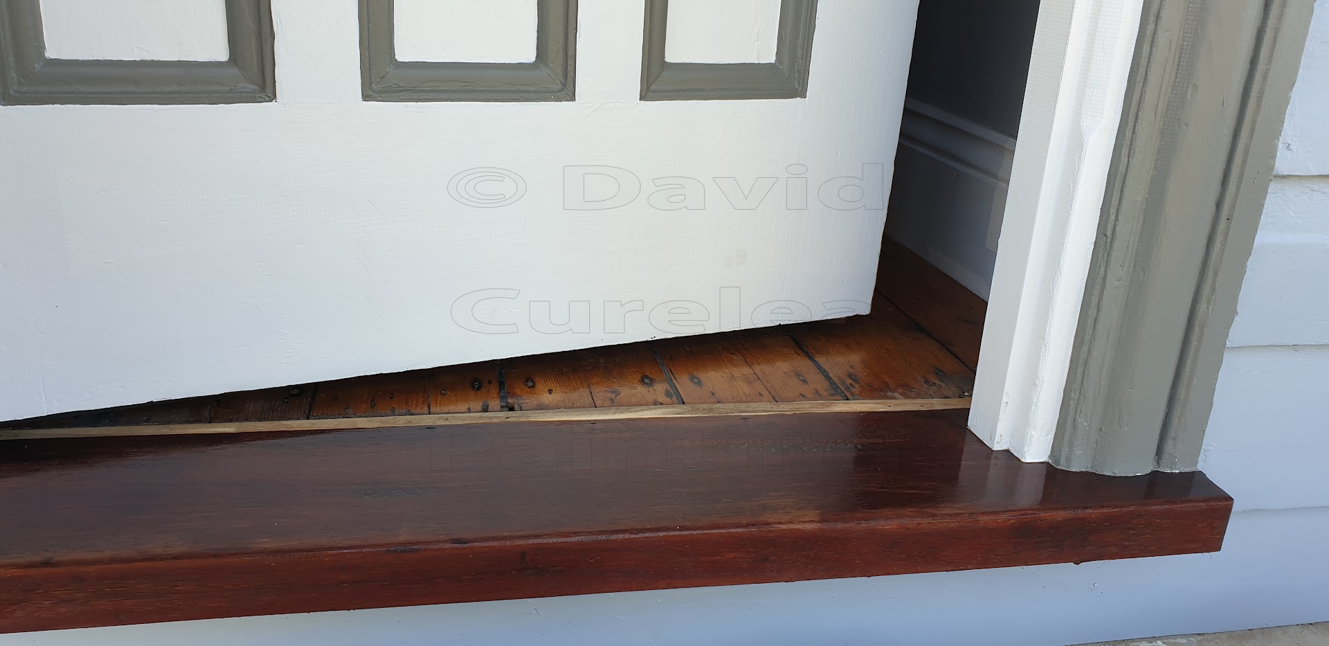 A painted door frame above a timber threshold