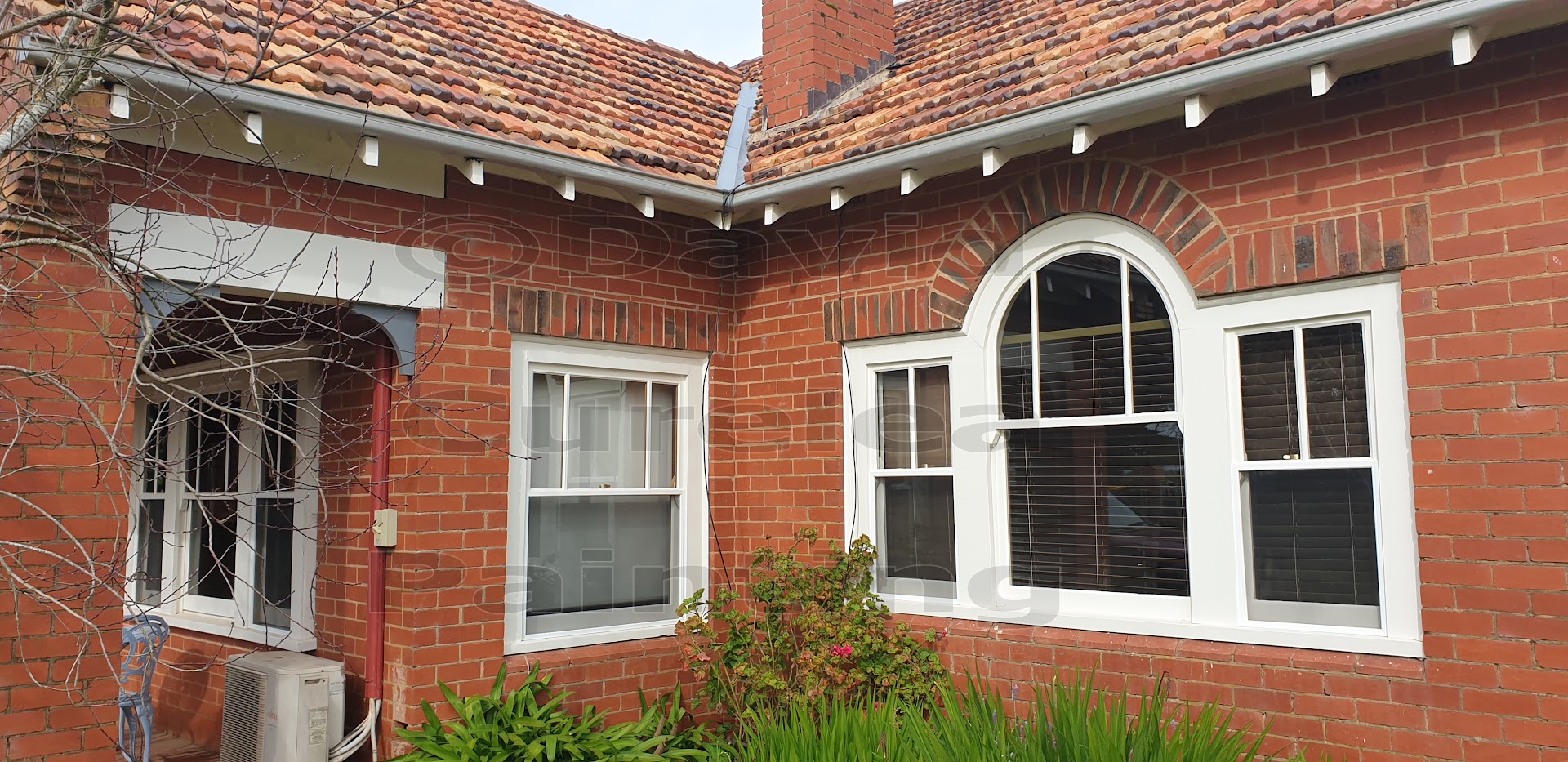 A red brick home with painted white window frames