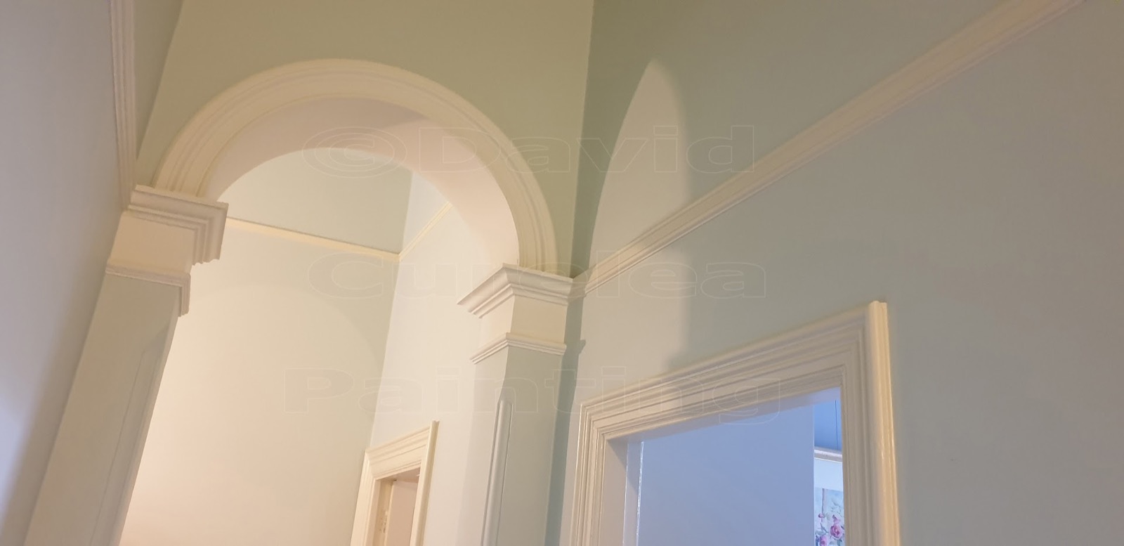 An arched interior opening with painted plasterwork