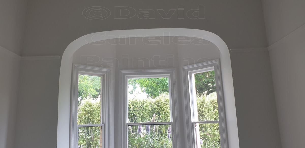 A bay window with painted frames in a white room