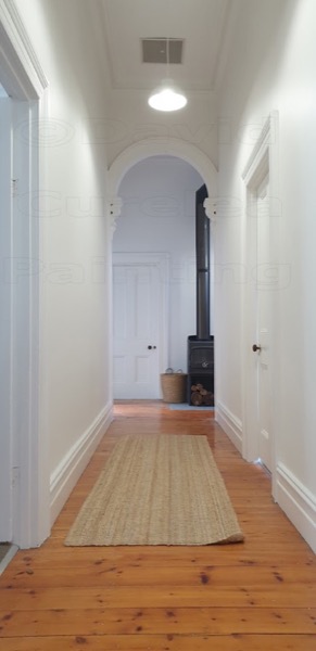 A hallway with painted walls and an arched opening