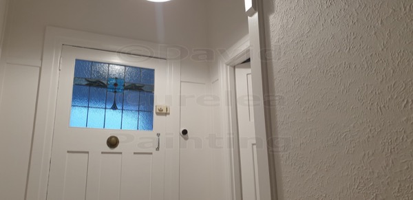 A painted front door with a small leadlight panel