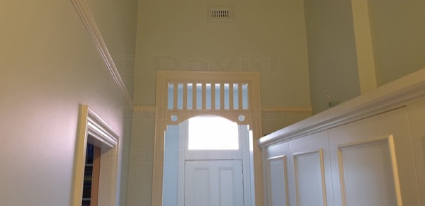 An interior hallway with painted wall panelling and a door