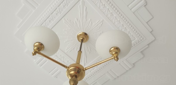 A ceiling rose and pendant light finished in white