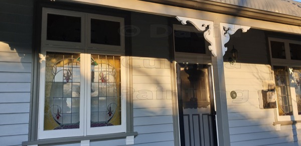 A weatherboard verandah with painted window frames and posts