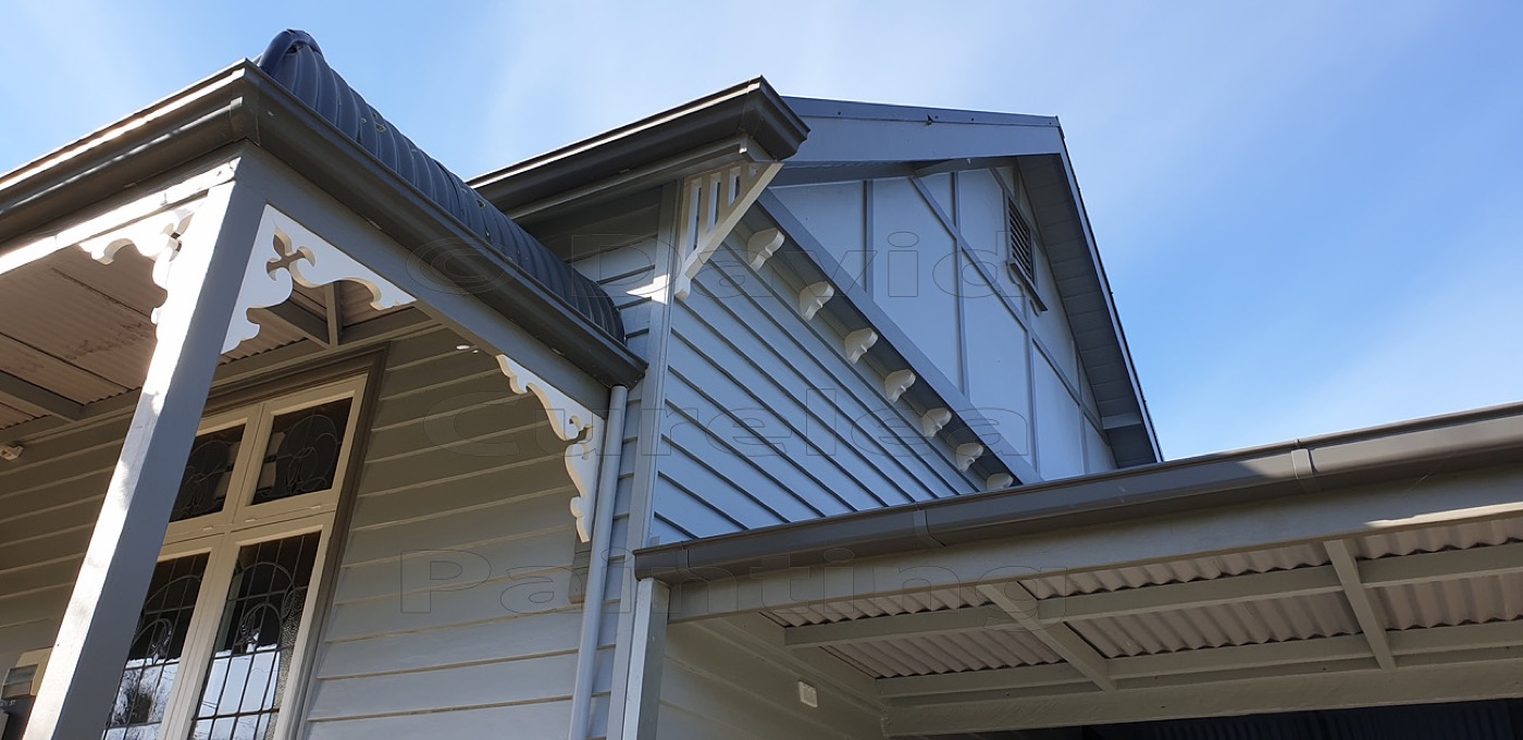 A painted gable, eaves and windows on a weatherboard home